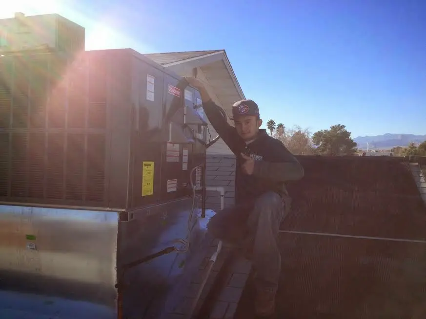 HVAC technician performing Air Duct Cleaning on a rooftop unit in North Bay Village